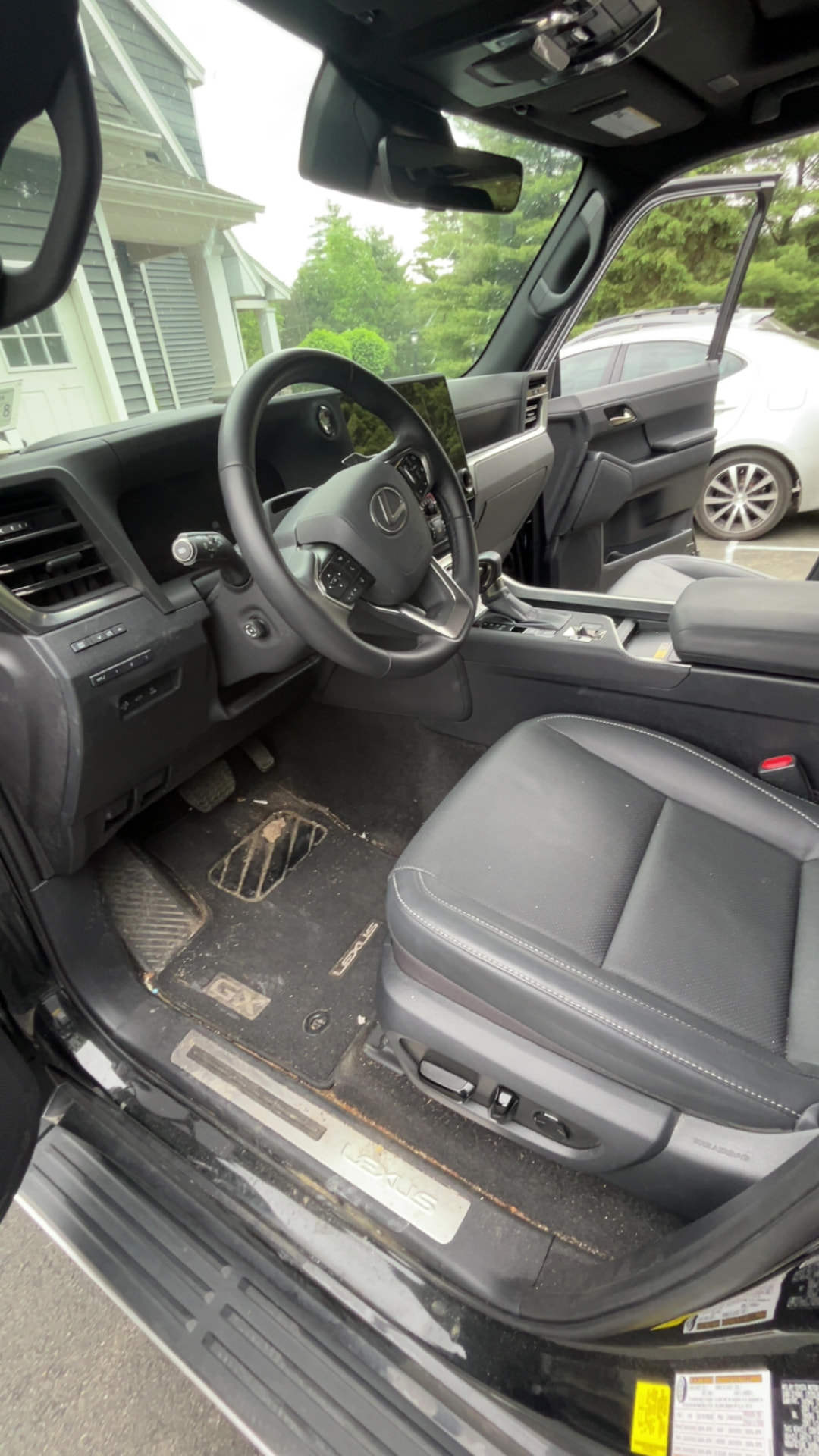 Lexus GX interior with dirty floor mats and debris before detailing